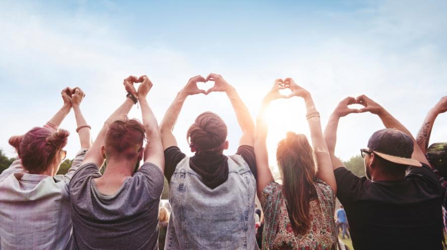 Group of people holding up heart hands.