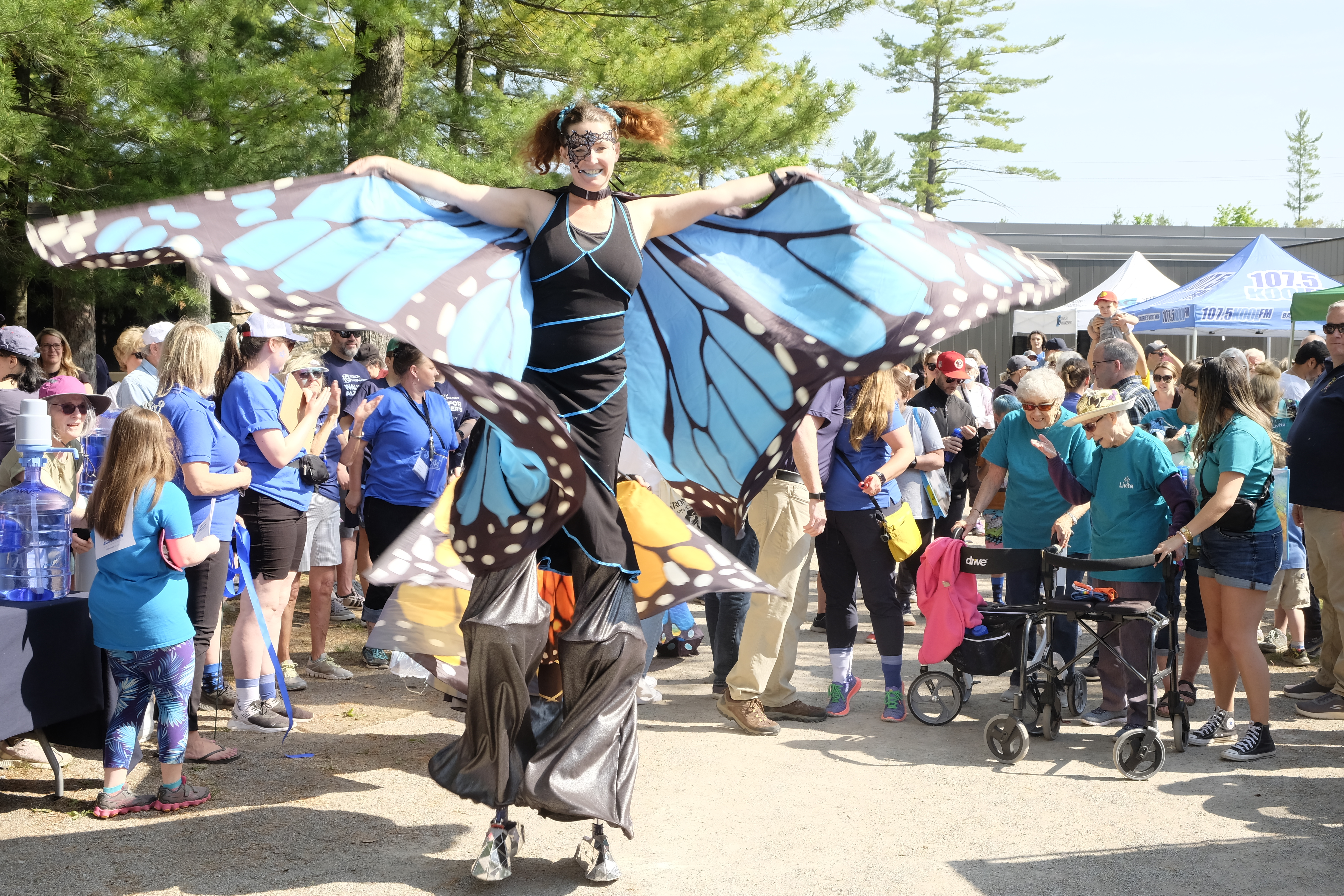 A person dressed as a butterfly on stilts