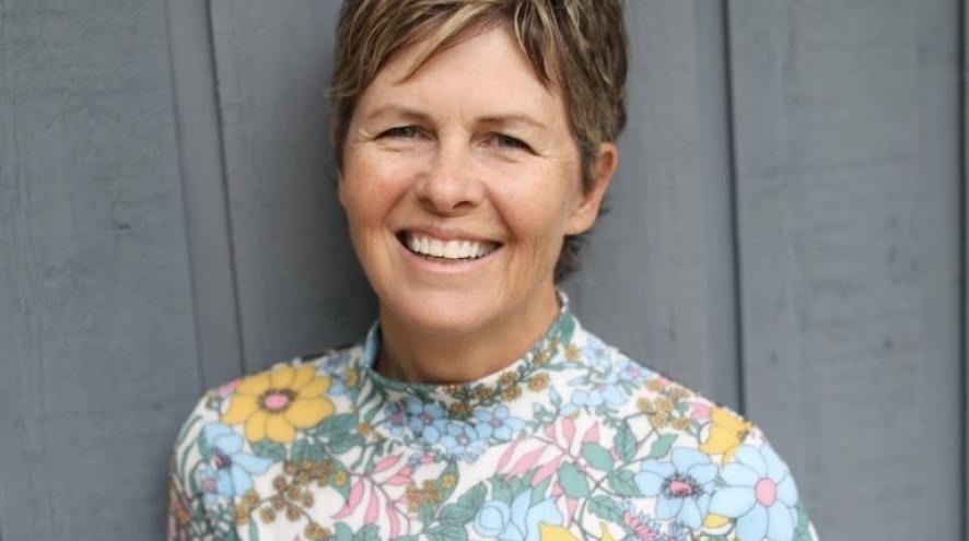 Picture of Lee Rinne against grey wooden wall.