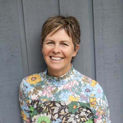 Picture of Lee Rinne against grey wooden wall.