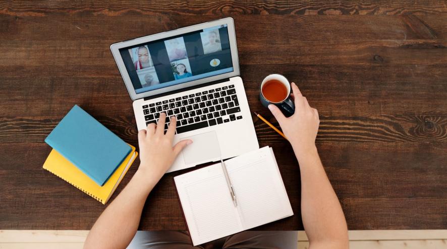 Aerial view of a person having a virtual meeting on their laptop.