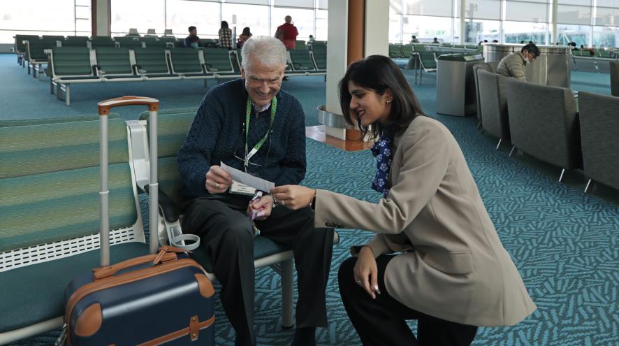 a young female assisting a man in an airport