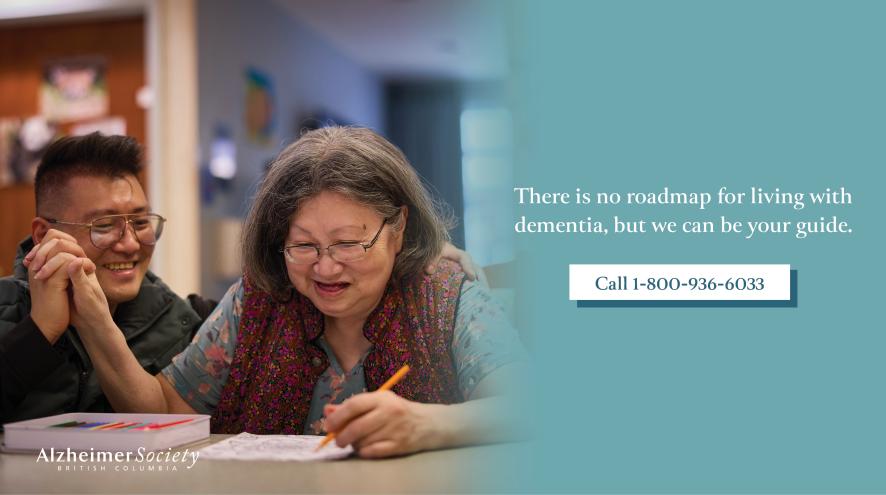 A son and mother holding hands at a table, text reads "There is no roadmap for living with dementia, but we can be your guide. Call 1-800-936-6033."
