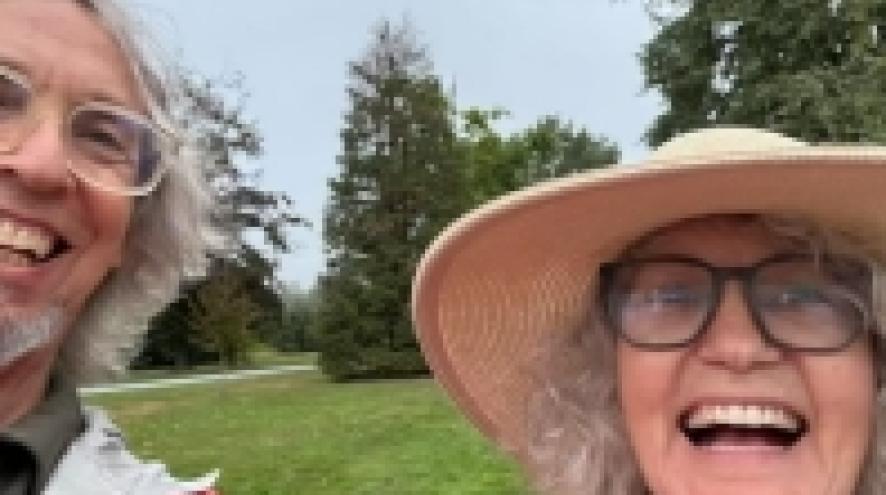 Tobias and Marsha, smiling in front of grass and trees