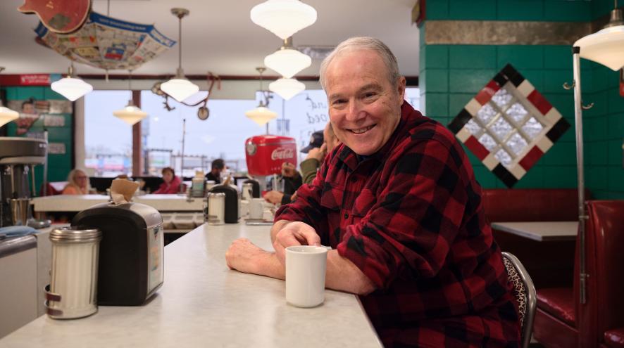 Fred Keating sitting at a booth at Bobby Sox Diner