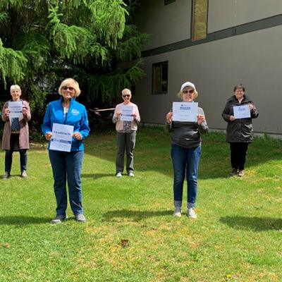 Seven volunteers of the IG Wealth Management Walk for Alzheimer's holding signs in support of the event in a social distanced formation