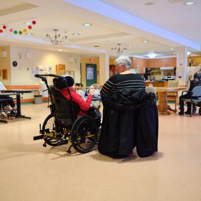 A mother and daughter sitting in a well-lit long-term care home.