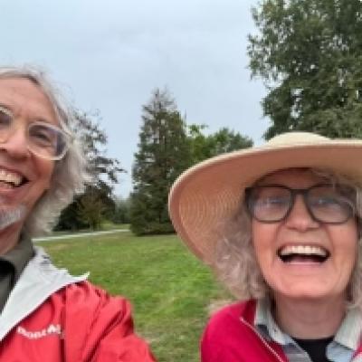 Tobias and Marsha, smiling in front of grass and trees
