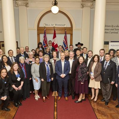 A large group of staff, MLAs, guests in the Hall of Honour at BC Legislature
