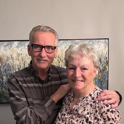 Dennis and Linda Griffiths standing together, smiling. Dennis has his hands on Linda's shoulders.