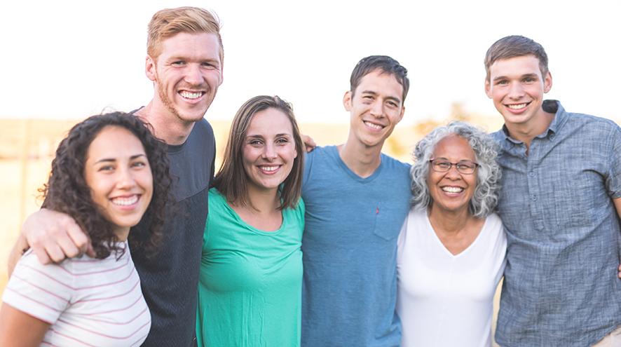 Group of six people, three men and three women smiling at the camera