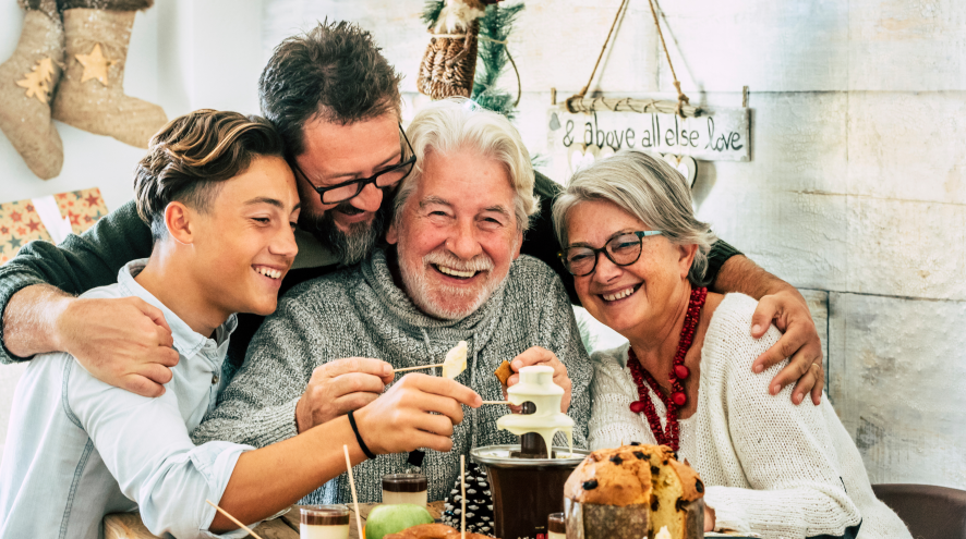 Family gathered together, embracing one another at table.