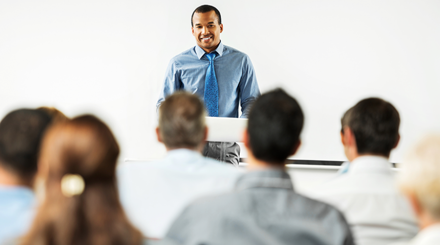 Middle-aged man giving lecture to an audience.