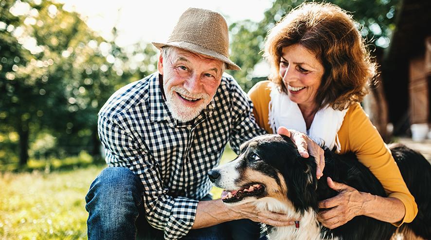 Senior couple playing with their dog.