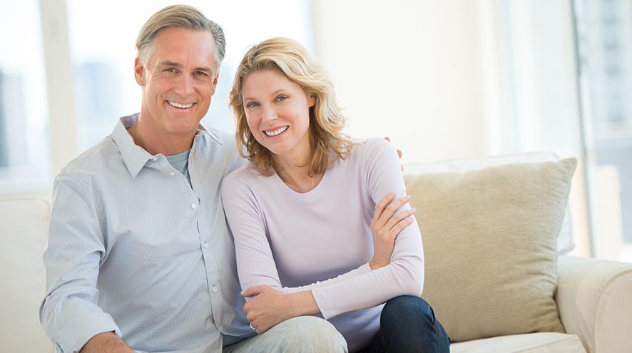 middle aged couple sitting on couch