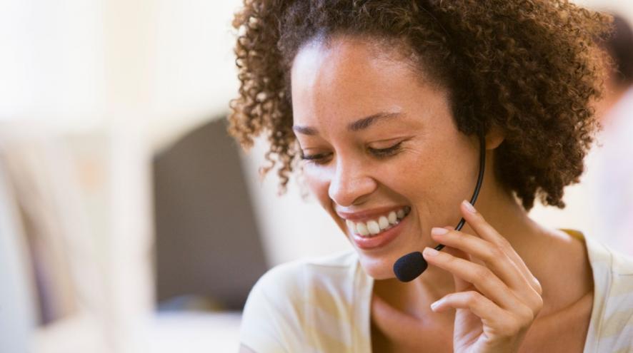 Woman wearing a headset and smiling.