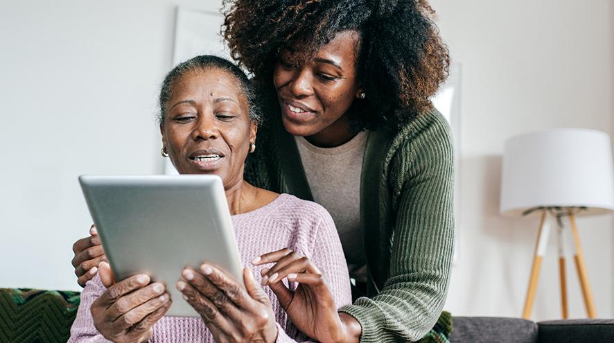 Mother and daughter using a computer tablet together.