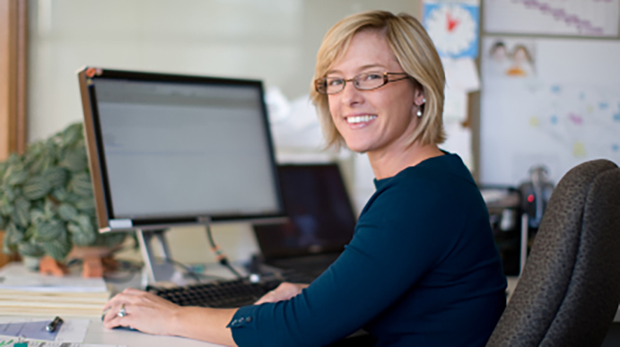 Woman at a desk smiling at the camera