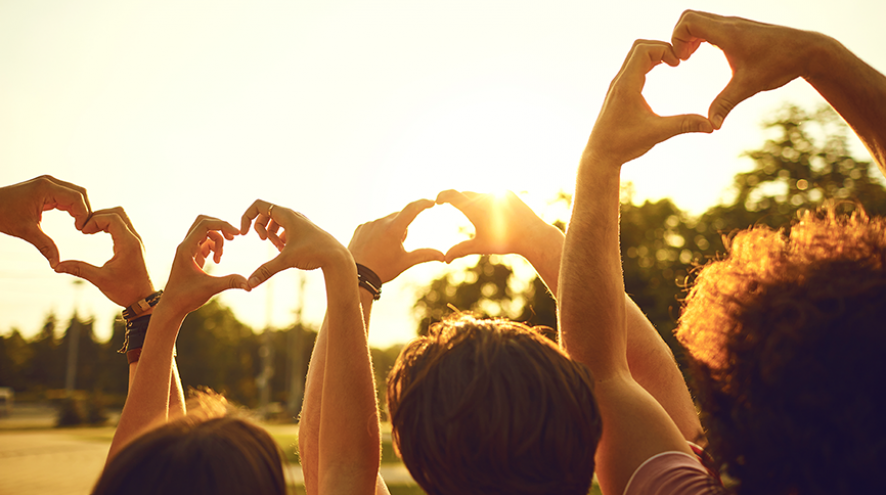 Hands making heart shapes toward the sky.