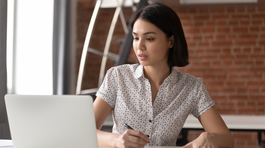 Young woman looking up something on her laptop.