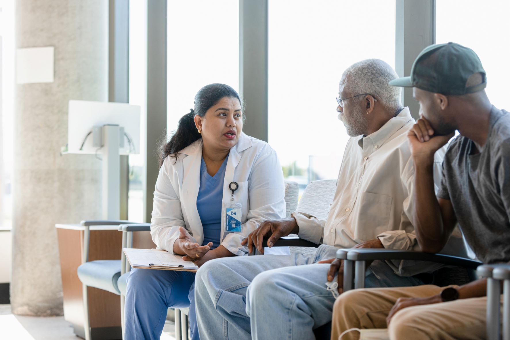 Doctor speaking with older man and son