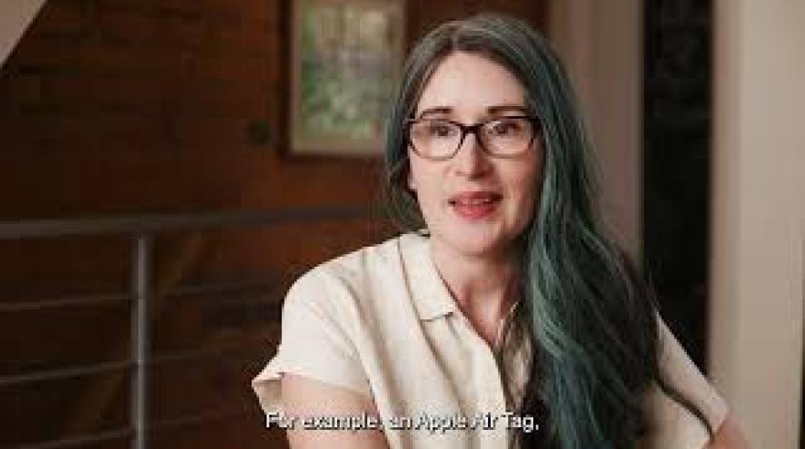 A woman sits at a kitchen table, talking