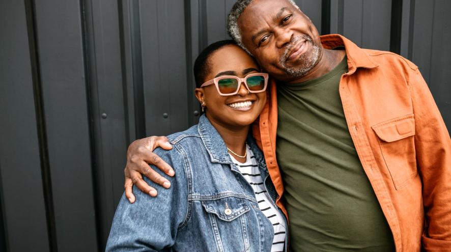 Younger woman in jean jacket and older man in orange shirt