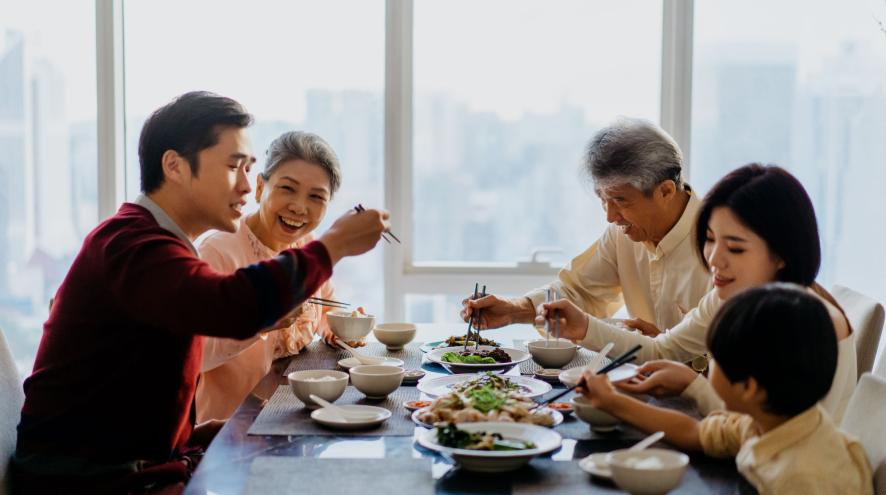 Family of 5 people, including elders and children, eating together