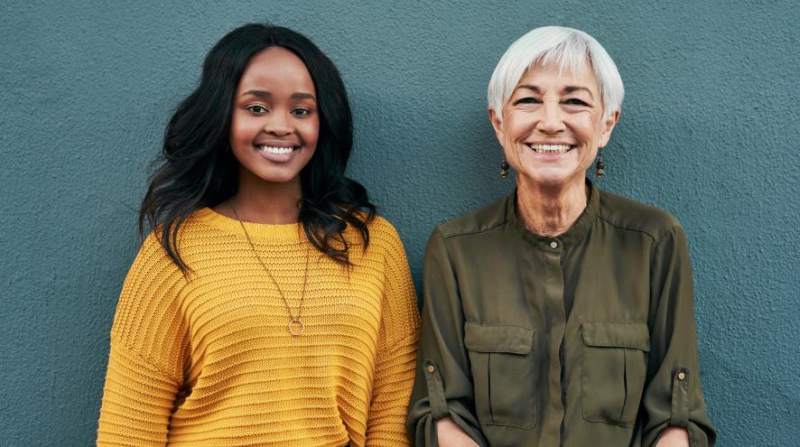 Young adult and senior standing side by side