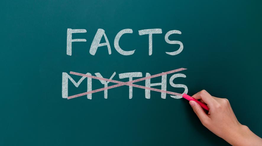 On a chalkboard, the word “myths” is being crossed out and replaced with the word “facts” 