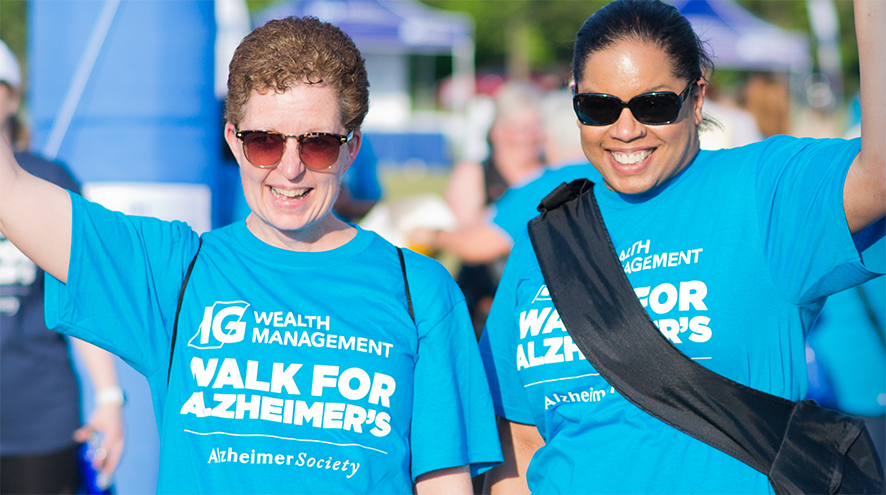 Two people waving at the camera during the Walk for Alzheimer's event.