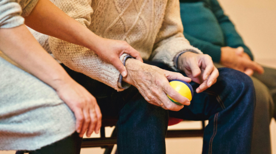 Image a woman holding a senior's hand.