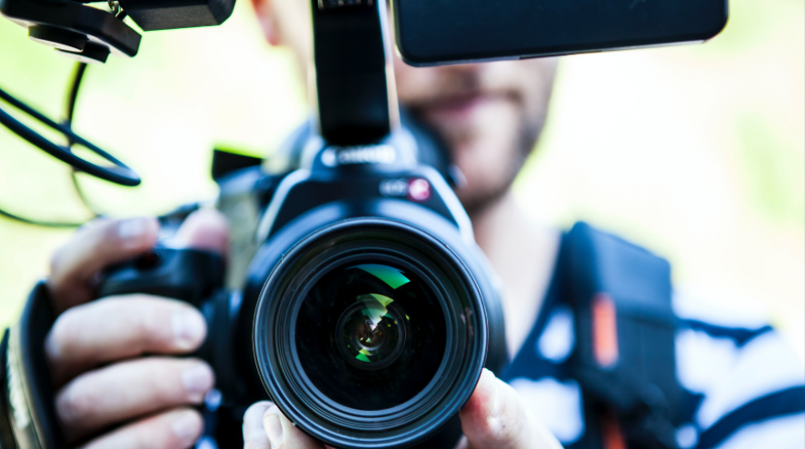 White man holding a camera/video camera