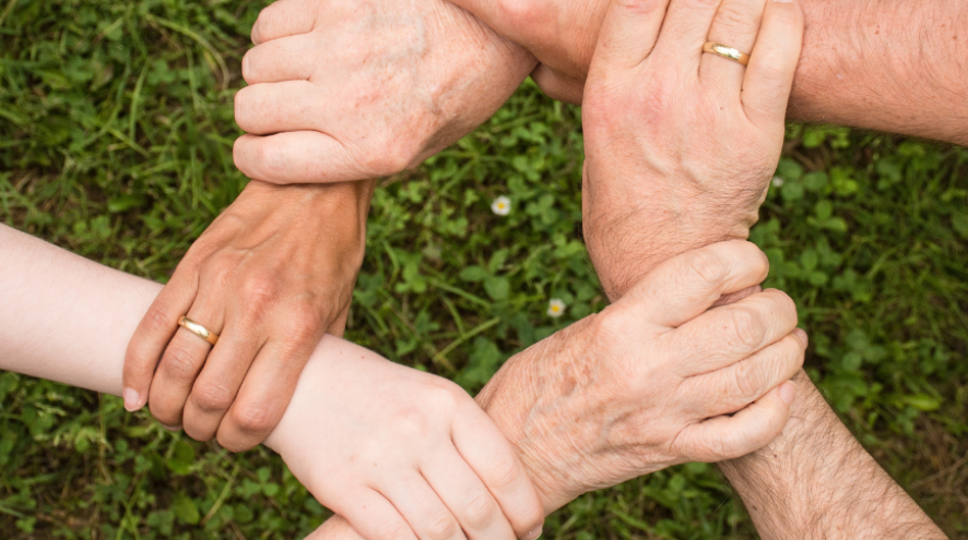 Image of various hands holding each other in a square shape